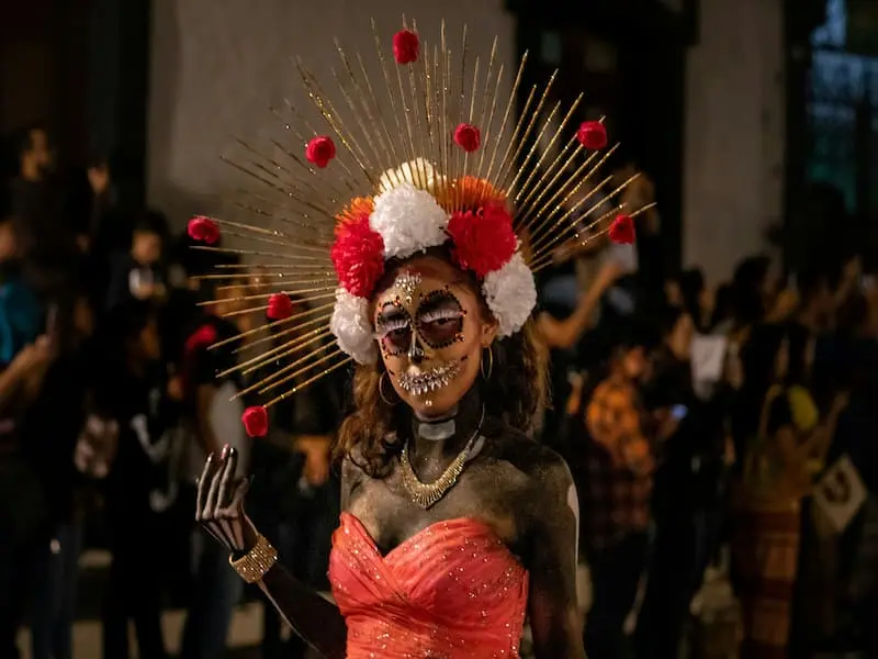 Traditional Catrina-style skull makeup and headdress worn at a Day of the Dead parade in Mexico