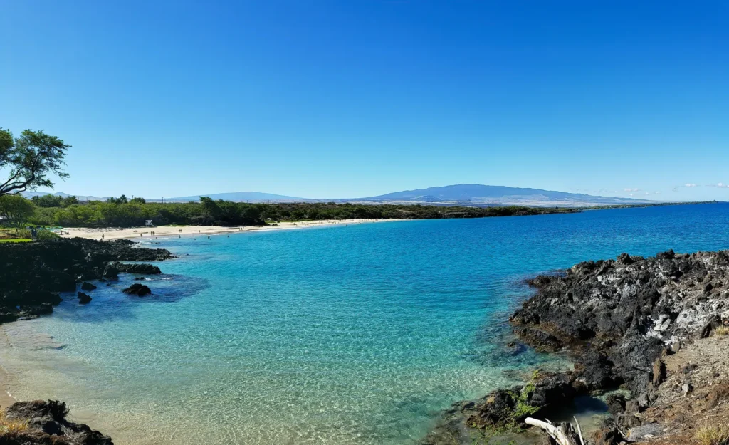 Turquoise water beach cove with a lava rock coastline in Hawaii