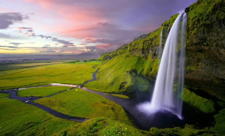 seljalandsfoss waterfall in Iceland under a pink summer sunset sky