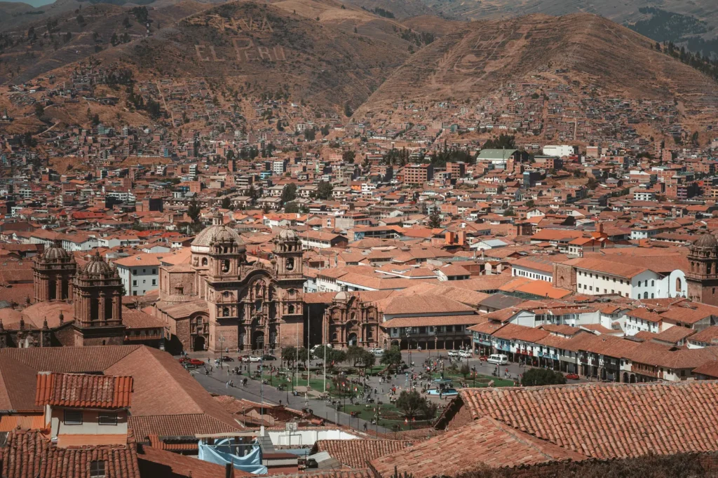 Aerial view of Cusco's historic center with cathedral domes and red-tiled roofs in the Peruvian Andes