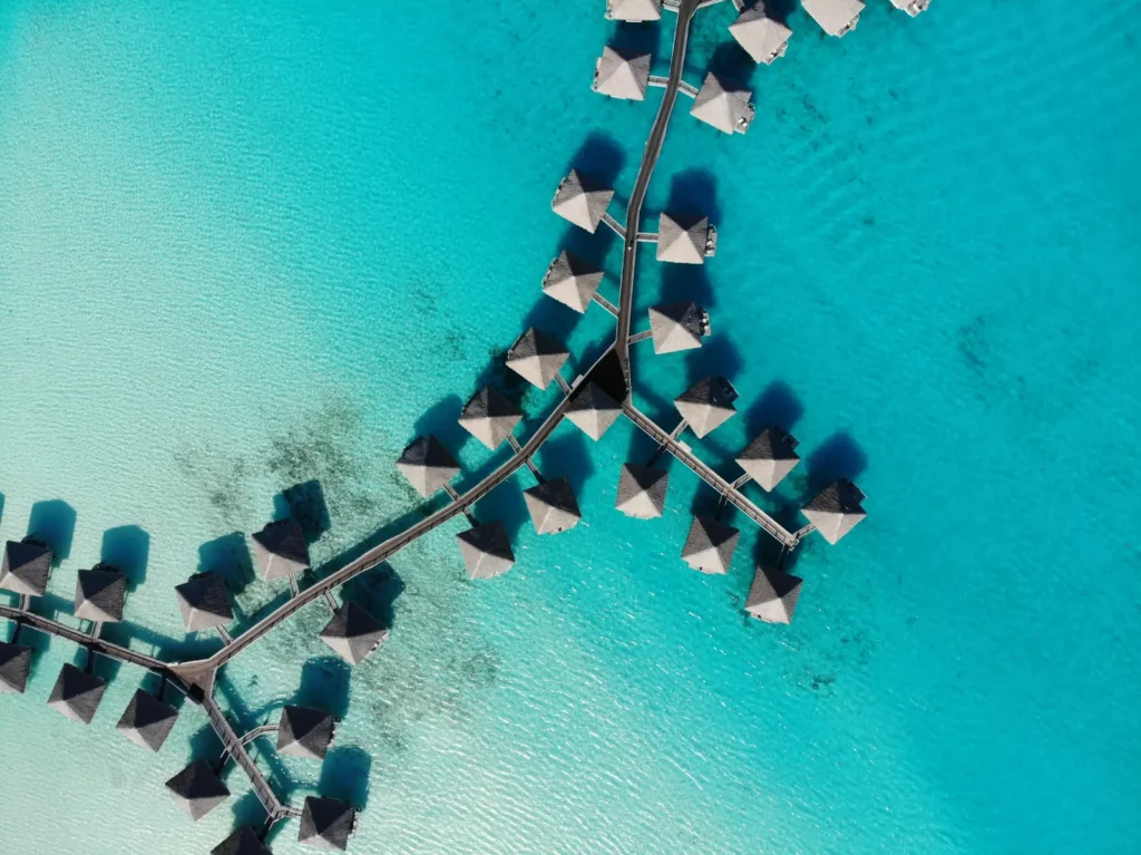 Aerial view of overwater bungalow jetties in Bora Bora's turquoise lagoon