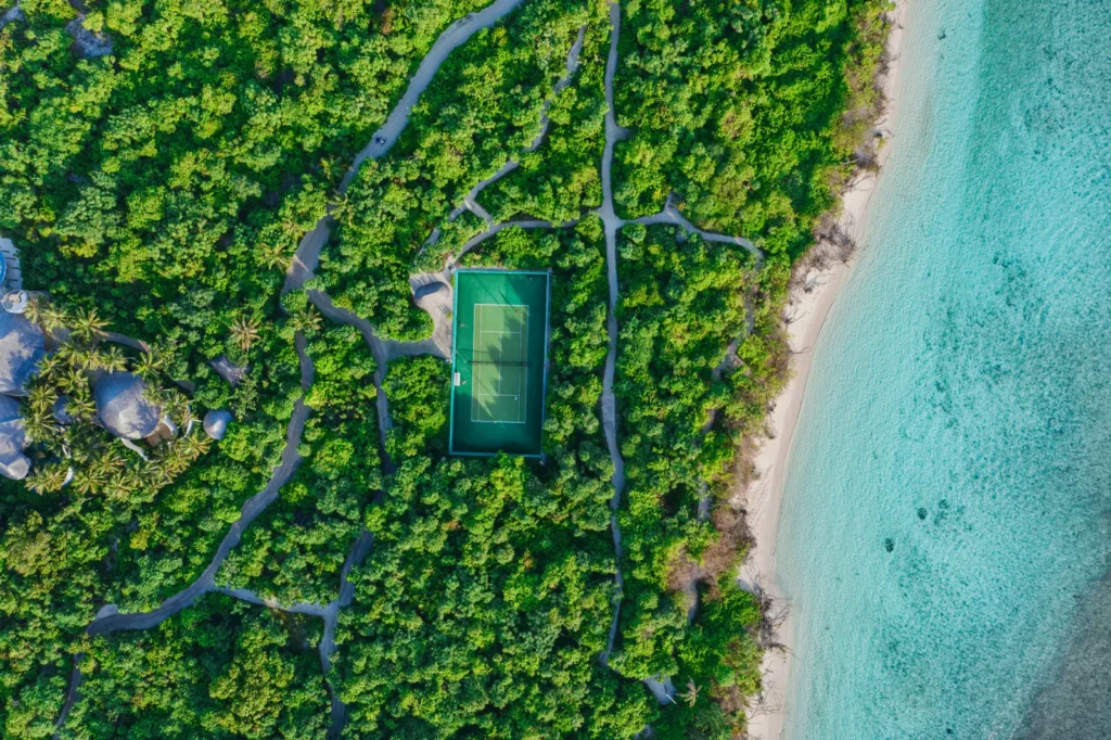 Aerial view of a resort tennis court surrounded by tropical foliage in Bora Bora