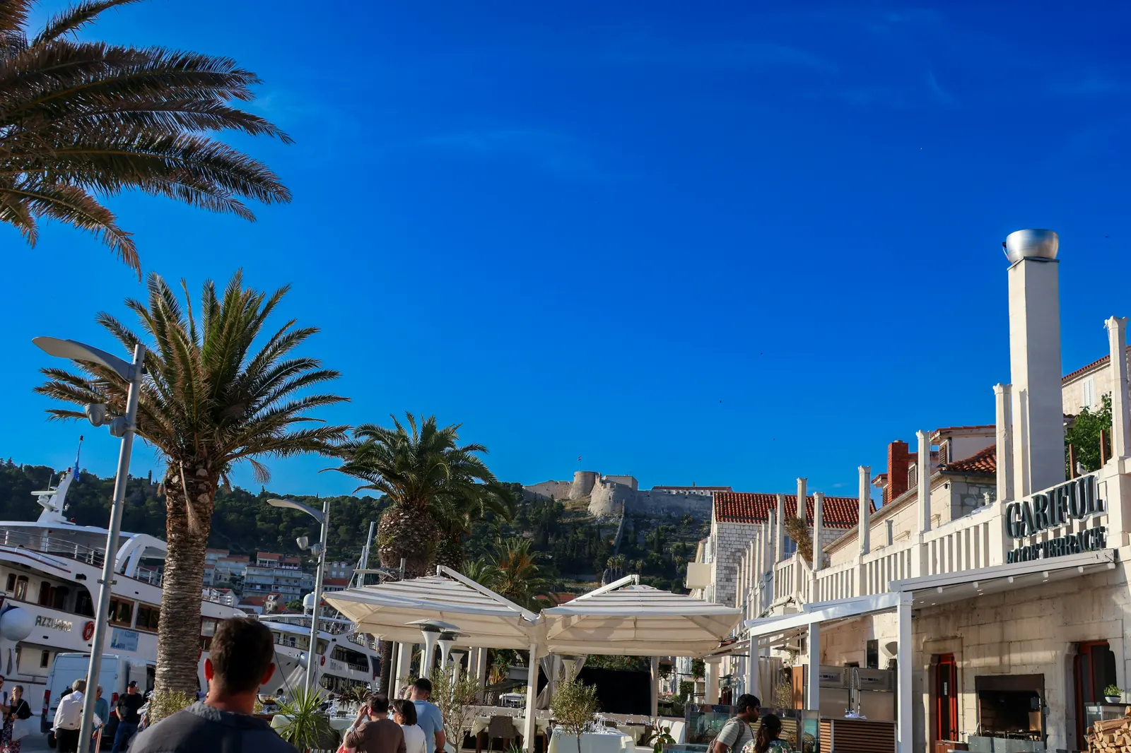 Hvar harbor waterfront with Spanish Fortress on the hillside above town