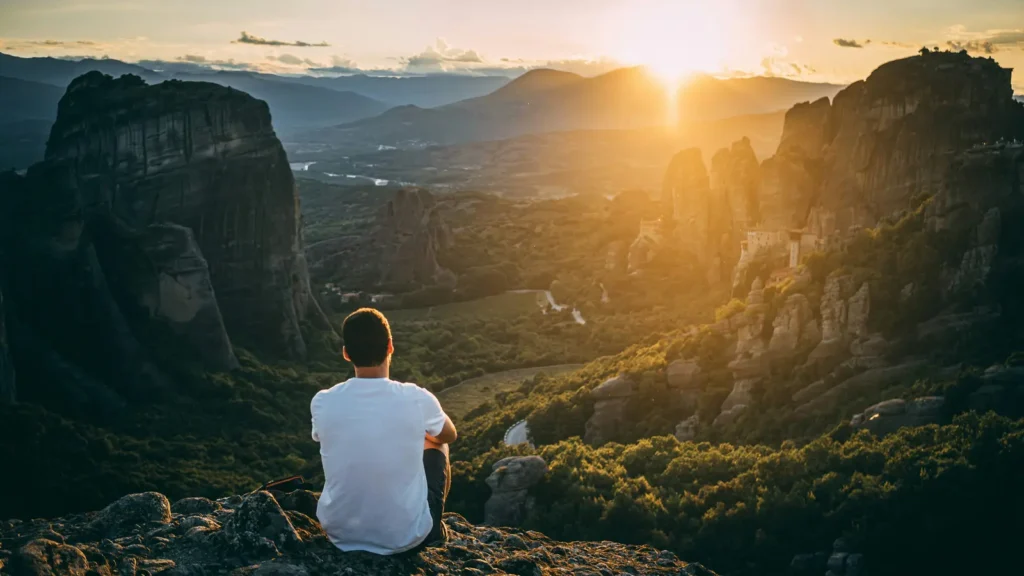 Hiker overlooking the Meteora monasteries at sunset in mainland Greece
