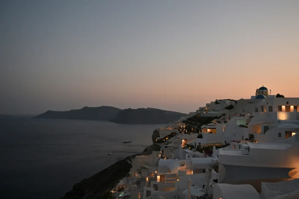 Santorini sunset in Oia with a blue-domed church