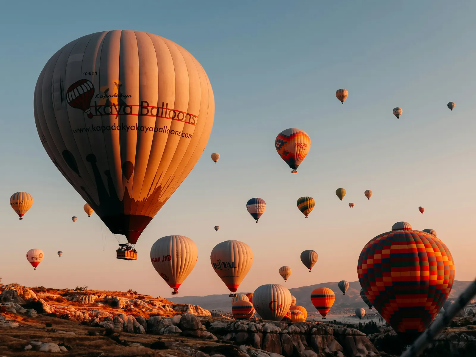 Dozens of hot air balloons filling the sky over Cappadocia at sunrise