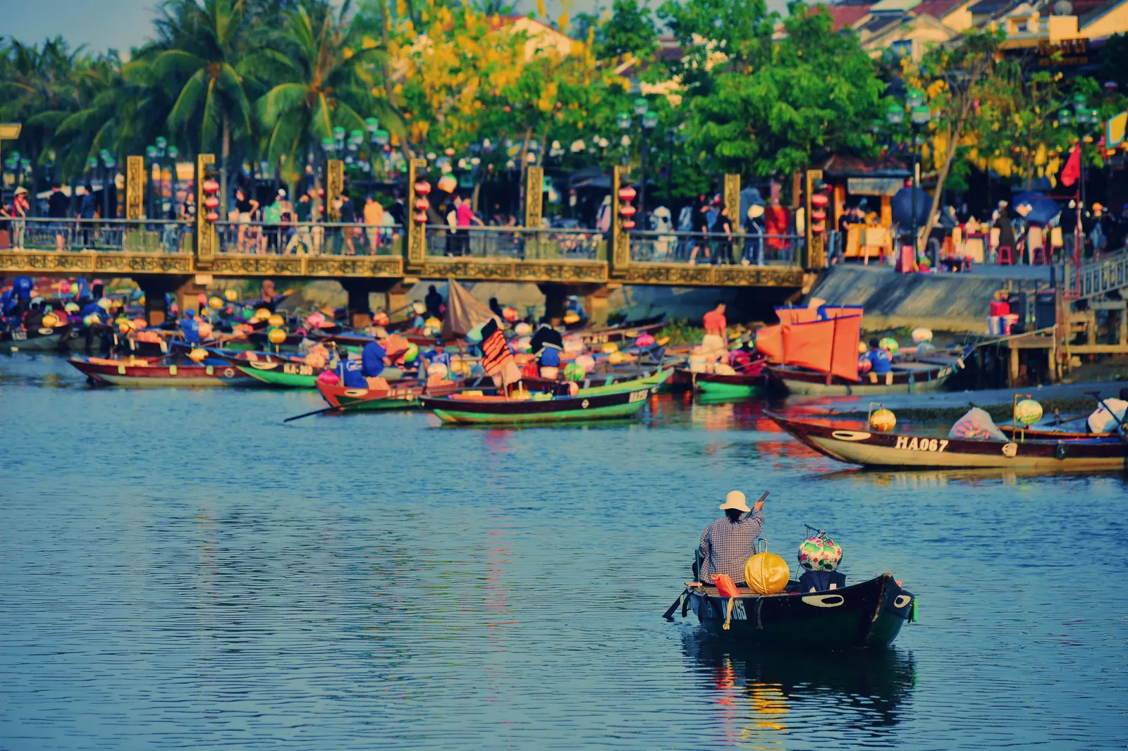 Traditional wooden boats decorated with lanterns on the Thu Bon River in Hoi An at sunset