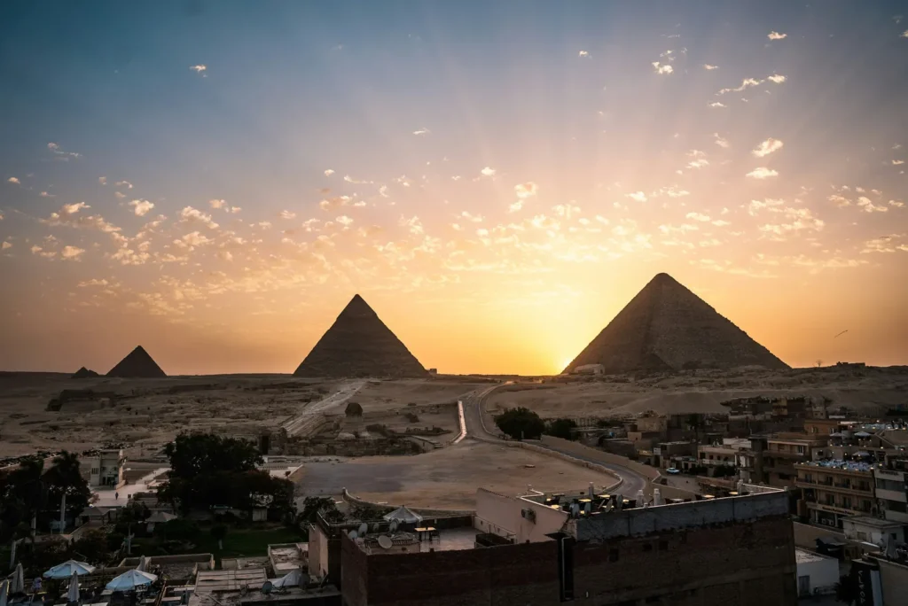 The Giza pyramids and Sphinx silhouetted against a golden sky over Cairo, Egypt