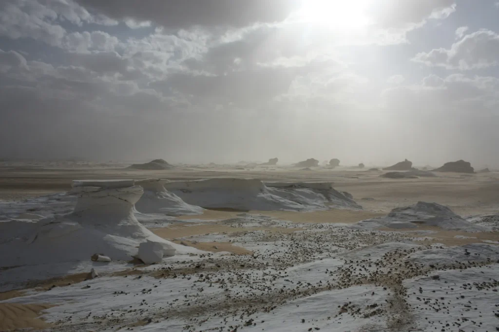 Chalk rock formations in Egypt's White Desert under a hazy, dusty sky