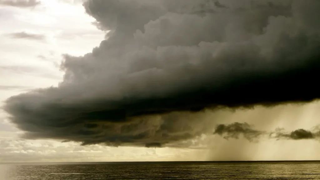 Dark storm cloud with rain falling over the ocean